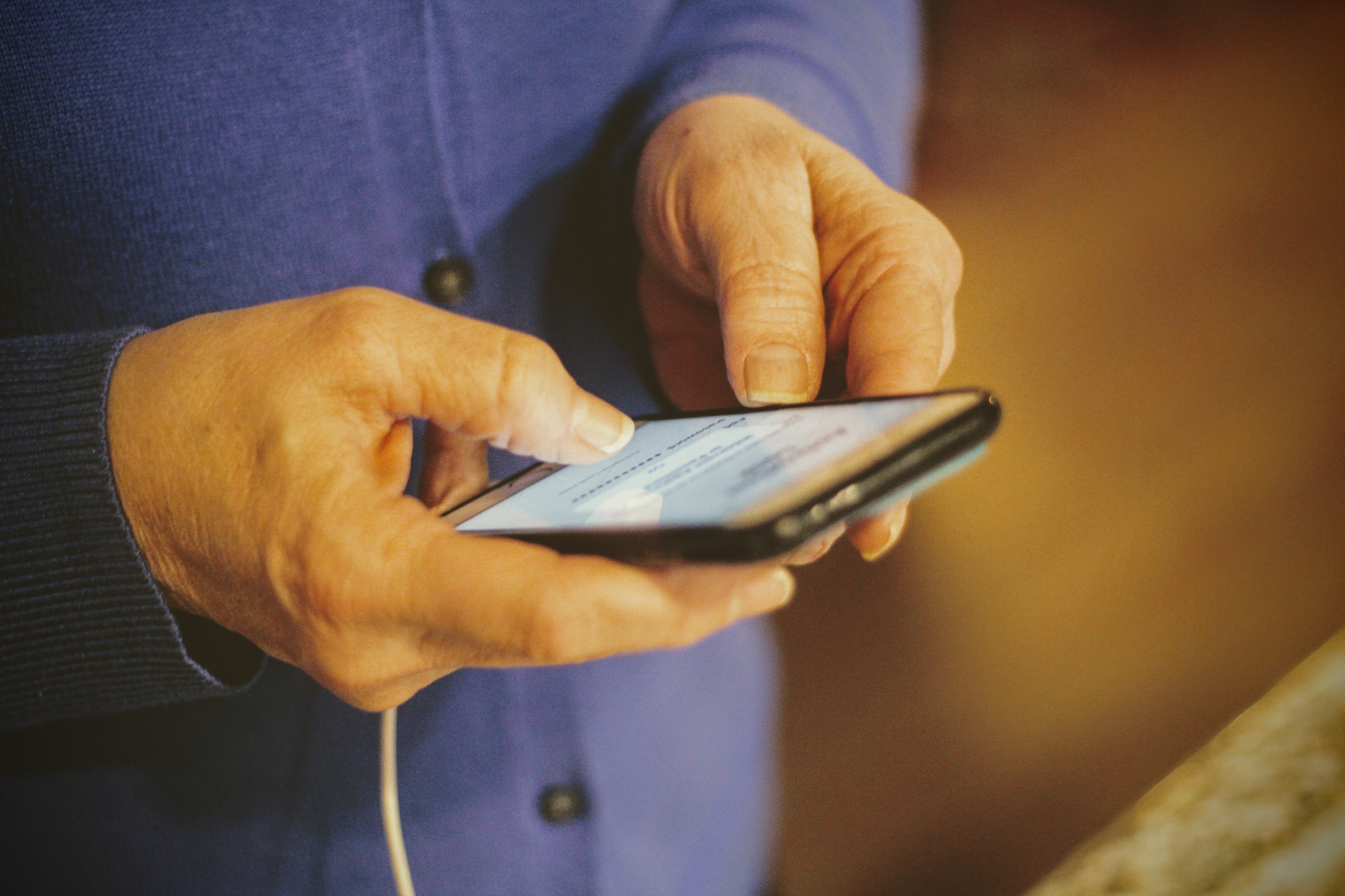 Elderly person holding mobile phone