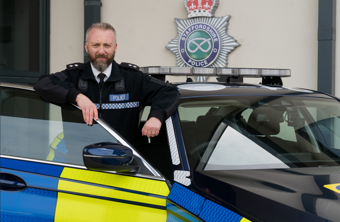 Inspector Mark Joynson standing beside a police car at HQ