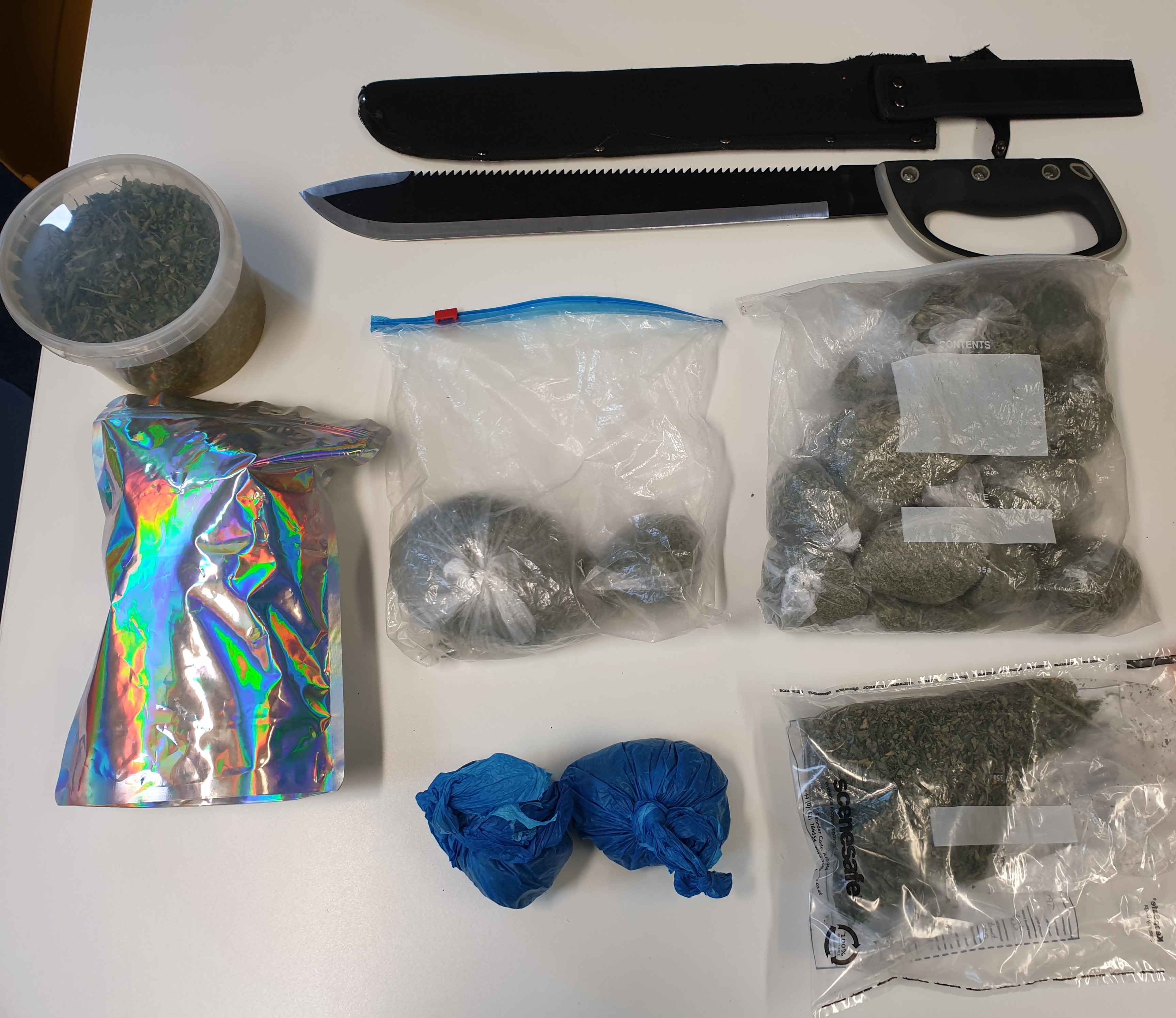 Image of the items seized during the warrants, including a machete, a sheath and cannabis